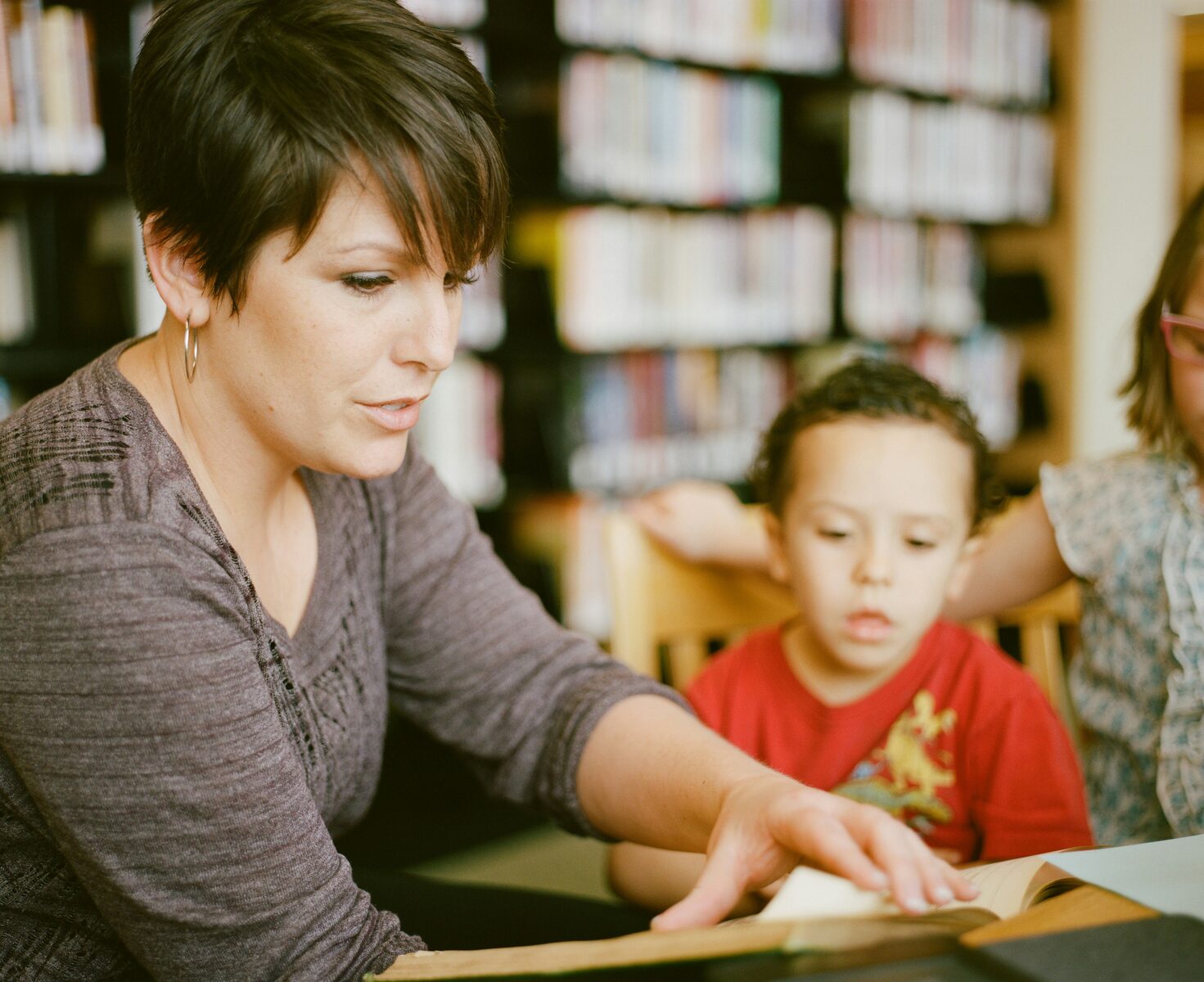 Tutor supporting a young learner with reading